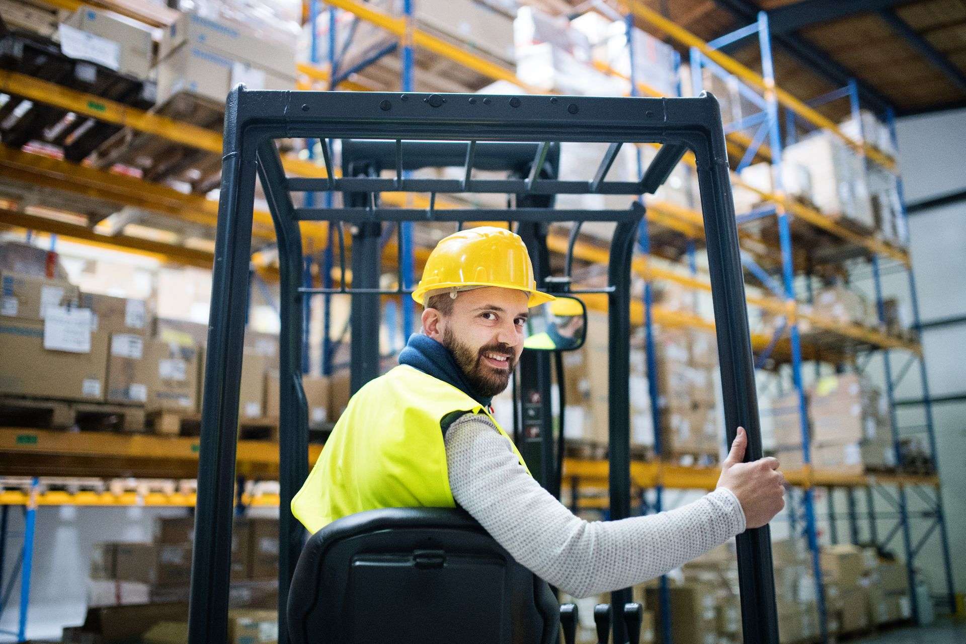 Warehouse worker operating a forklift in a distribution center, surrounded by stacked boxes, illustrating logistics and fulfillment services in Jacksonville.