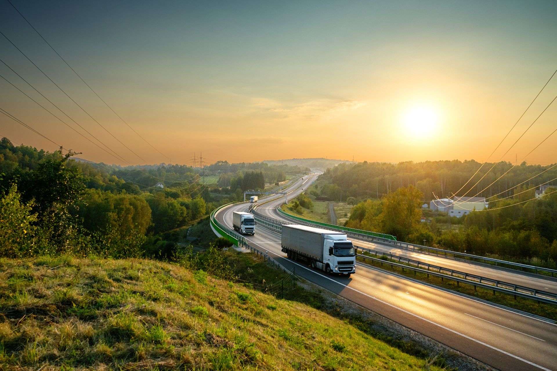 Trucks on a highway at sunset, symbolizing logistics and transportation services in Jacksonville, enhancing supply chain efficiency and delivery capabilities.