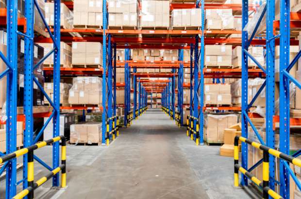 Warehouse interior with organized shelving units, stacked boxes, and clear pathways, illustrating Skinner Moving & Storage's warehousing and inventory management solutions in Jacksonville.