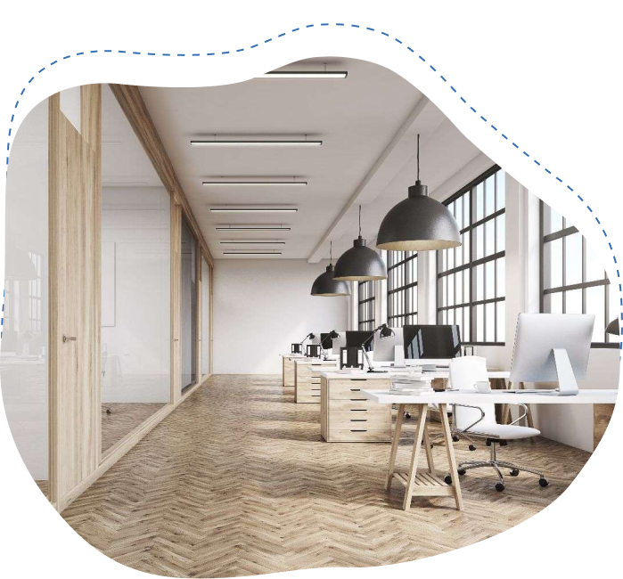 Modern office interior featuring workstations, large windows, and pendant lighting, illustrating efficient commercial space design for businesses.