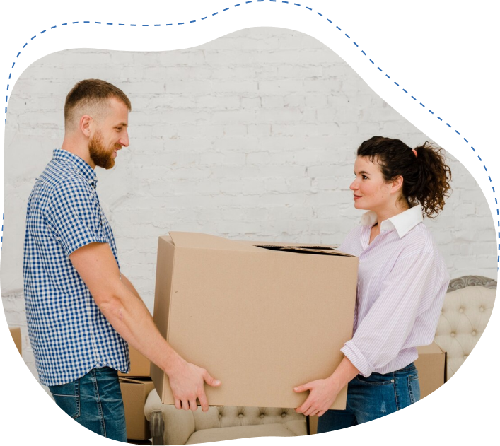 Two movers handing over a large cardboard box in a bright, modern interior, showcasing professional white glove delivery service for furniture and valuable items.